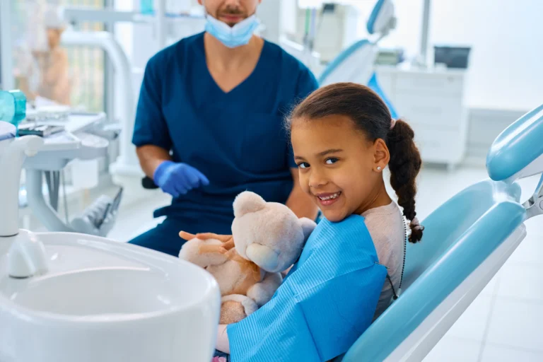 Girl with a teddy bear in the dentist's chair