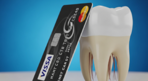 Kreditkarte neben einem Zahn auf blauem Hintergrund