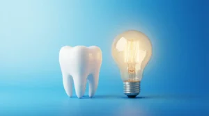 Zahn und Glühbirne auf blauem Hintergrund