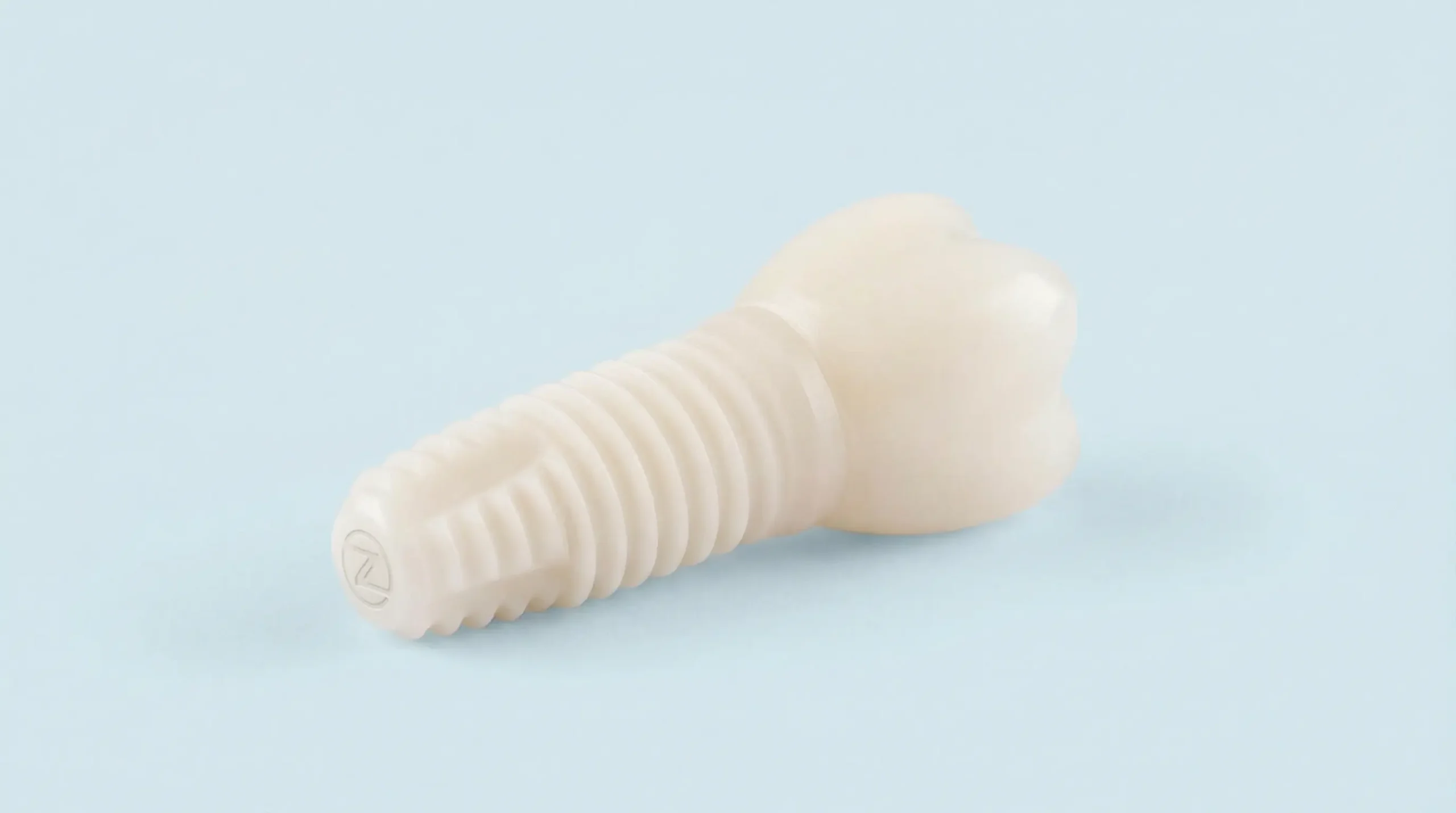 Keramisches Zahnimplantat auf hellblauem Hintergrund