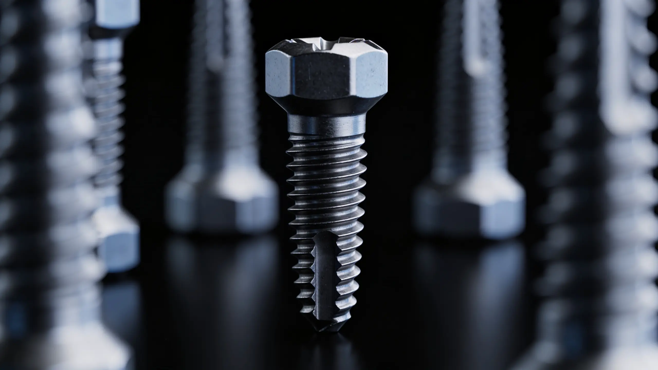 Metallschraube mit Gewinde auf schwarzem Hintergrund