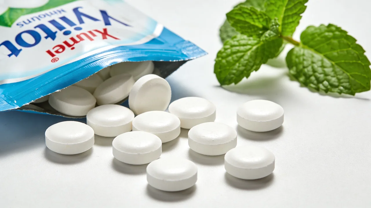 Xylit-Tabletten neben Verpackung und frischer Minze